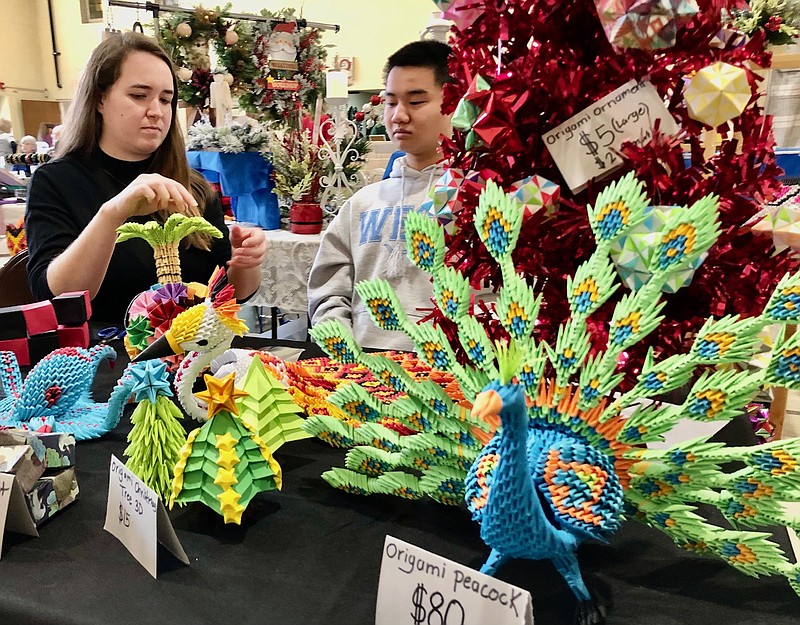 Joe Gamm/News Tribune photo: 
Preston Priest, right, applies details to an origami palm tree while his sister Noelle Dehn steadies it Saturday morning, Nov. 25, 2023, at the annual Kristkindlmarkt at Central Church. The church hosts the market, along with a cookies sale and its Breakfast Bonanza, each year.