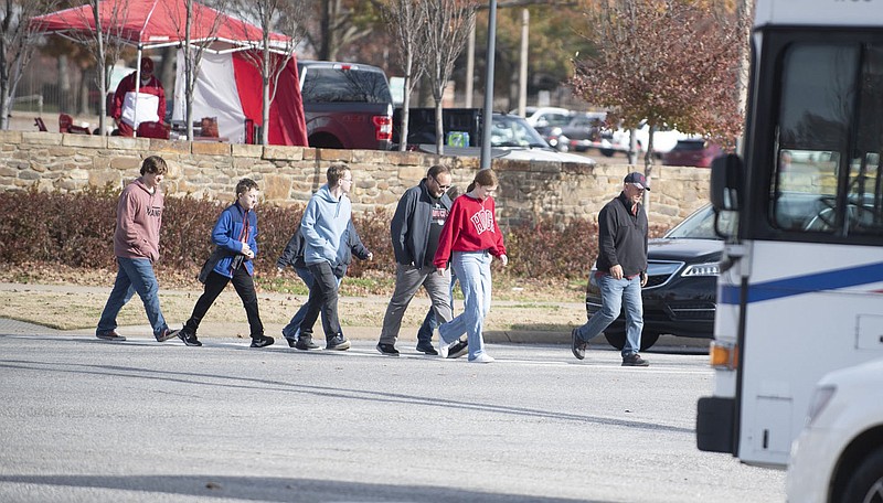Pedestrians cross MLK Blvd. in Fayetteville Friday Nov. 24, 2023.   Two people were killed in three days while trying to cross one short strech of roadway in Fayetteville, part of a national spike in pedestrian and cyclist fatalities. According to a 2022 study by the Governors Highway Safety Association (GHSA), there has been a 77% increase in pedestrian deaths across the country since 2010. All other traffic-related deaths rose 25%.Visit nwaonline.com/photo for today's photo gallery. (NWA Democrat-Gazette/J.T. Wampler)