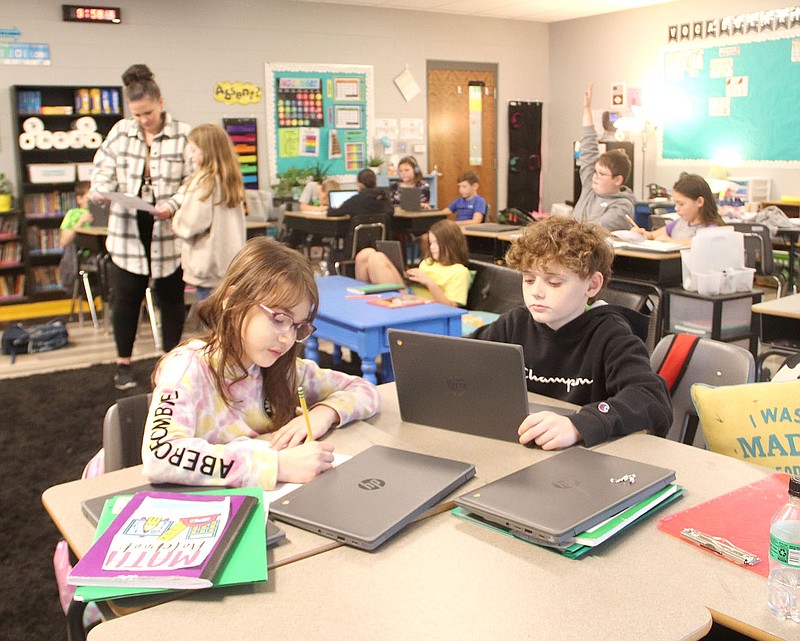 Stephanie Arivett (background left), a fourth grade teacher at Prairie Grove Middle School, helps a student in the background, as Addison Smith (foreground left) and Camden Ball take a test on Nov. 17 before schools dismissed for the Thanksgiving holiday.

(NWA Democrat-Gazette/Lynn Kutter)