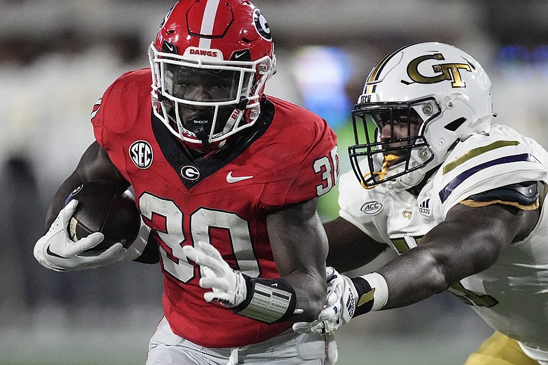 Georgia running back Daijun Edwards (30) is chased by Georgia Tech defensive lineman Kevin Harris (11) during the second half of an NCAA college football game, Saturday, Nov. 25, 2023, in Atlanta. (AP Photo/John Bazemore)