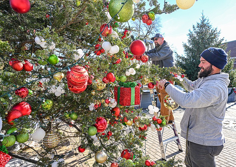 Julie Smith/News Tribune photo: 
Zac Baladenski, near, and Jeremy Smith make sure all the ornaments and lights are secure and facing forward as they apply the finishing touches to the Mayor's Christmas Tree at the north end of Bolivar Street in Jefferson City. The duo used hundreds of cable ties to attach the decorations to the branches of the cedar tree that was cut down at Binder Park for the city's tree. Baladenski and Smith work for the Parks, Recreation and Forestry Department and were almost finished preparing the area for the scene of Thursday night's tree-lighting ceremony.