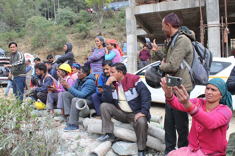 People watch rescue operations at the site of an under-construction road tunnel that collapsed in Silkyara in the northern Indian state of Uttarakhand, India, Tuesday, Nov. 28, 2023. Officials in India said Tuesday they were on the verge of rescuing the 41 construction workers trapped in a collapsed mountain tunnel for over two weeks in the country's north, after rescuers drilled their way through debris to reach them. (AP Photo)