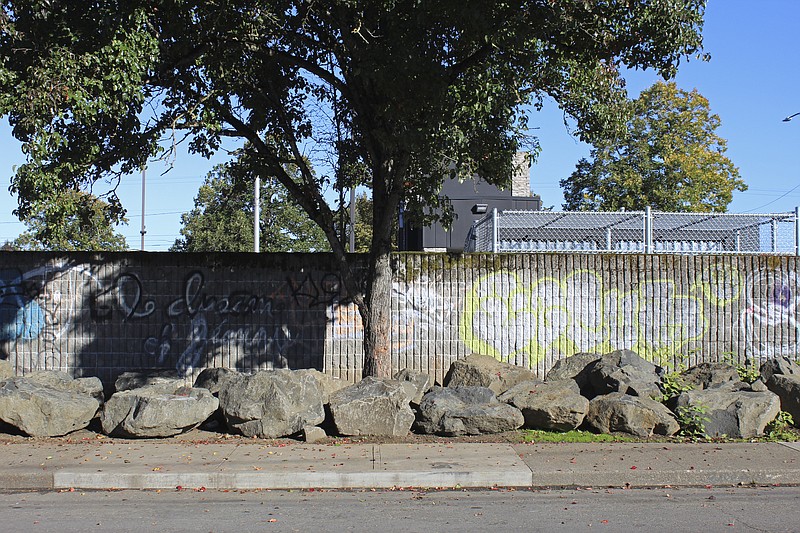 Roughly 30 large boulders occupy the narrow strip of land between a sidewalk and a parking lot wall in Portland, Ore., on Oct. 17, 2023. The boulders were installed sometime after late July at the site of a former homeless encampment to prevent tents from being set back up. The encampment was cleared several times over the course of the year. Cities across the U.S. are struggling with and cracking down on tent encampments as the number of homeless people grows, largely due to a lack of affordable housing. Homeless people and their advocates say sweeps are cruel and costly, and there aren't enough homes or beds for everyone. (AP Photo/Claire Rush)