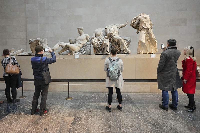 Visitors look at ancient sculptures that are part of the Parthenon Marbles at the British Museum in London, Tuesday, Nov. 28, 2023. Greek officials said Tuesday Nov. 28, 2023 that they will continue talks with the British Museum on bringing the Parthenon Marbles back to Athens, despite U.K. Prime Minister Rishi Sunak cancelling a meeting with his Greek counterpart where the contested antiquities were due to be discussed.(AP Photo/Kirsty Wigglesworth)