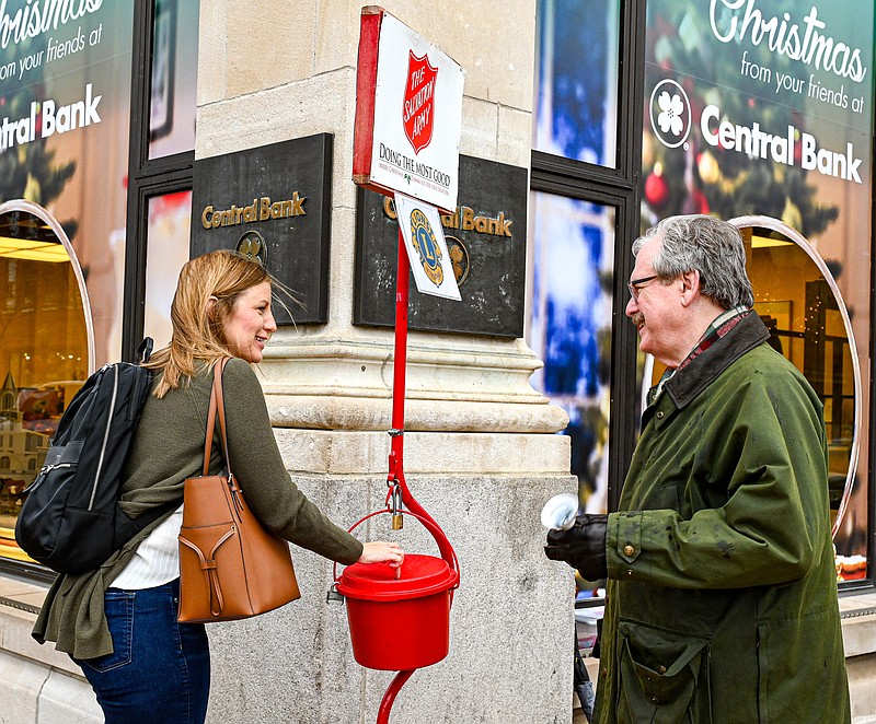 Julie Smith/News Tribune
Emily Kampeter places a donation in a bucket Friday as Sam Bushman stands in front of Central Bank on the same corner he has manned for many years while ringing a bell for the Salvation Army Red Kettle. Bushman is a member of the Jefferson City Host Lions Club and joined other members at various locations across the city to raise funds for the Salvation Army Center of Hope.