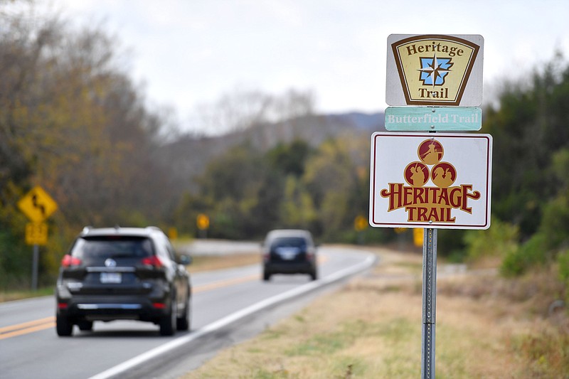 Traffic passes Friday, Nov. 4, 2022, past a sign promoting Arkansas 265 as a Heritage Trail that follows the original Butterfield Stagecoach route in Fayetteville. (NWA Democrat-Gazette/Andy Shupe)