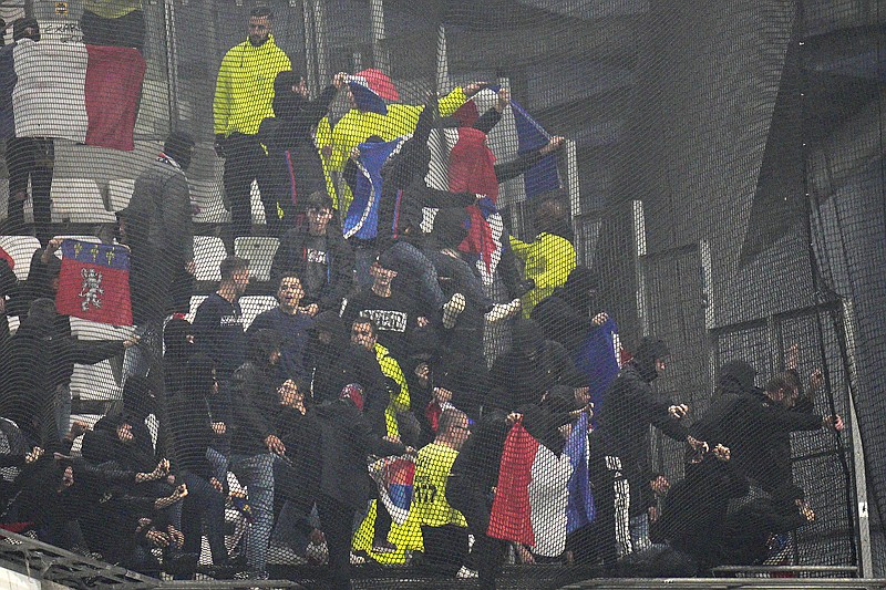 ARCHIVO - Hinchas de Lyon intentan romper la malla en las gradas previo al partido contra el 
Olympique de Marsella, el domingo 29 de octubre de 2023, en el estadio Velodrome de Marsella. (AP Foto/Daniel Cole)
