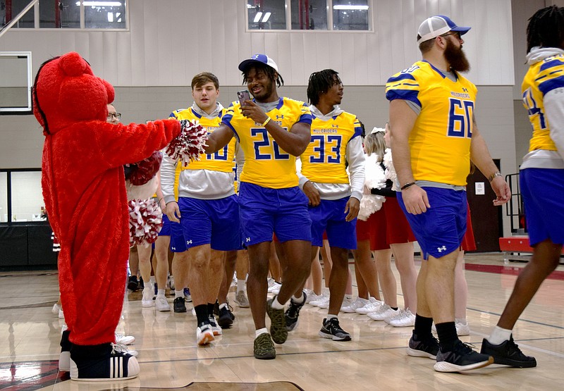 Southern Arkansas University junior defensive back Trevon Stacker fist bumps the Razorback mascot as the team walks down the tunnel Friday, Dec. 1, 2023, at Arkansas Middle School in Texarkana, Ark. SAU and the Missouri Western Griffons will tussle for the 10th Live United Bowl title Saturday, Dec. 2 at Arkansas High School's Razorback Stadium. Kickoff is at noon.(Staff photo by Stevon Gamble)