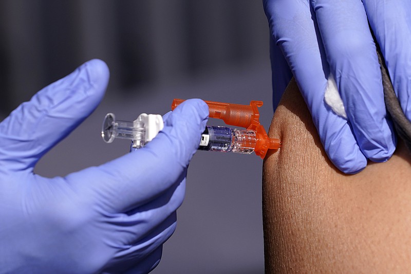 FILE - A patient is given a flu vaccine Friday, Oct. 28, 2022, in Lynwood, Calif.   Seasonal flu continues to pick up steam in the U.S. But among respiratory viruses, COVID-19 remains the main cause of hospitalizations and deaths, health officials said Friday, Dec. 1, 2023.  (AP Photo/Mark J. Terrill, File)