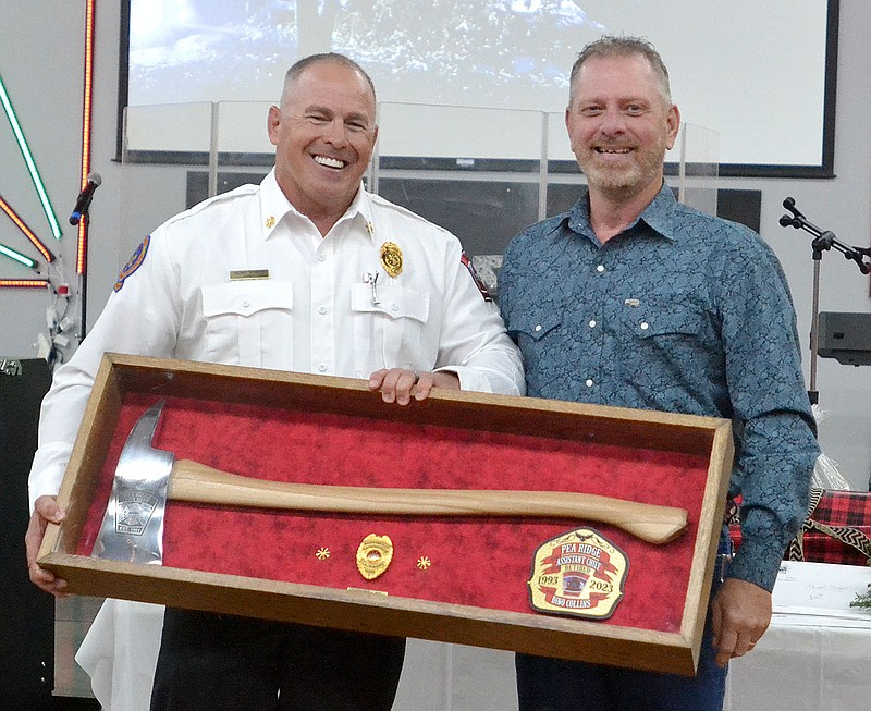 Annette Beard/Pea Ridge TIMES
Former firefighter Dino Collins was presented a shadow box displaying an axe, badge and shield by Fire Chief Clint Bowen commemorating his many years of service to the Pea Ridge Fire-EMS Department during the annual Christmas party Friday, Dec. 1, 2023.