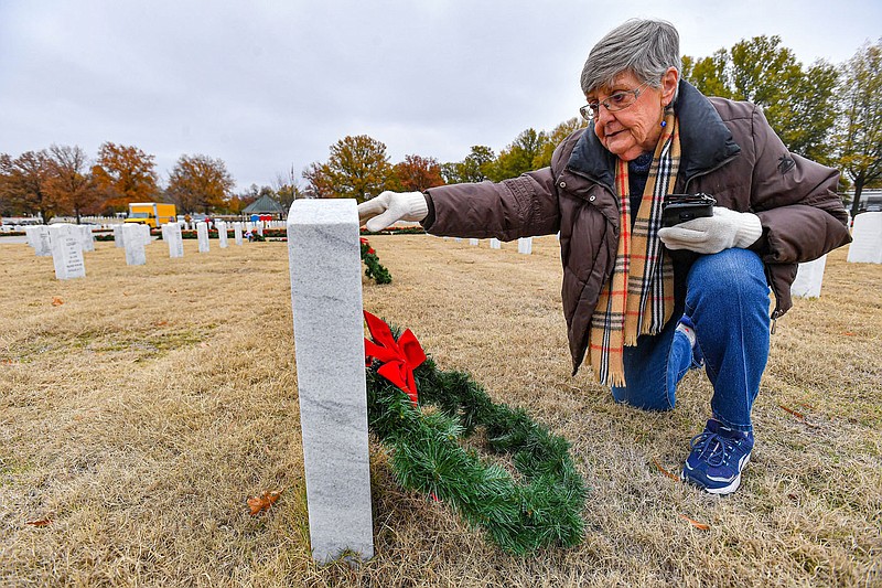 Shirley Intres of Van Buren lays a wreath at the headstone of her brother-in-law, Saturday, Dec. 2, 2023, during the annual Christmas Honors tradition at the Fort Smith National Cemetery in Fort Smith. Families of those buried at the cemetery were given the first opportunity Saturday morning to lay wreaths at any of its approximately 19,000 headstones. After a ceremony honoring veterans, members of the public gathered to lay the rest of the wreaths at the remaining headstones. The wreaths will remain on display until Jan. 5, 2024. Visit rivervalleydemocratgazette.com/photo for today's photo gallery.
(River Valley Democrat-Gazette/Hank Layton)
