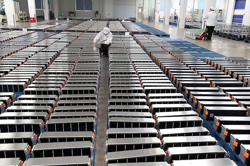 This photo taken on March 12, 2021 shows a worker with car batteries in a factory for Xinwangda Electric Vehicle Battery Co. Ltd in Nanjing in China's eastern Jiangsu province. Electric Vehicle Battery Co. makes lithium batteries for electric cars and other uses. (Stringer photo/AFP via Getty Images/TNS)