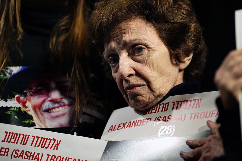 Irena Tati holds a picture of her grandson, Alexander, held by Hamas in Gaza, during a demonstration to call for the release of hostages in the Hostages Square at the Museum of Art in Tel Aviv, Israel, Saturday Dec. 2, 2023. Troufanov, 28, was kidnapped from his parents' home in Kibbutz Nir Oz on Oct. 7 alongside his girlfriend, his mother, and his grandmother. Irene and Alexander's mother Lena Troufanov were recently released by Hamas during an exchange of Palestinian prisoners for hostages.(AP Photo/Ariel Schalit)