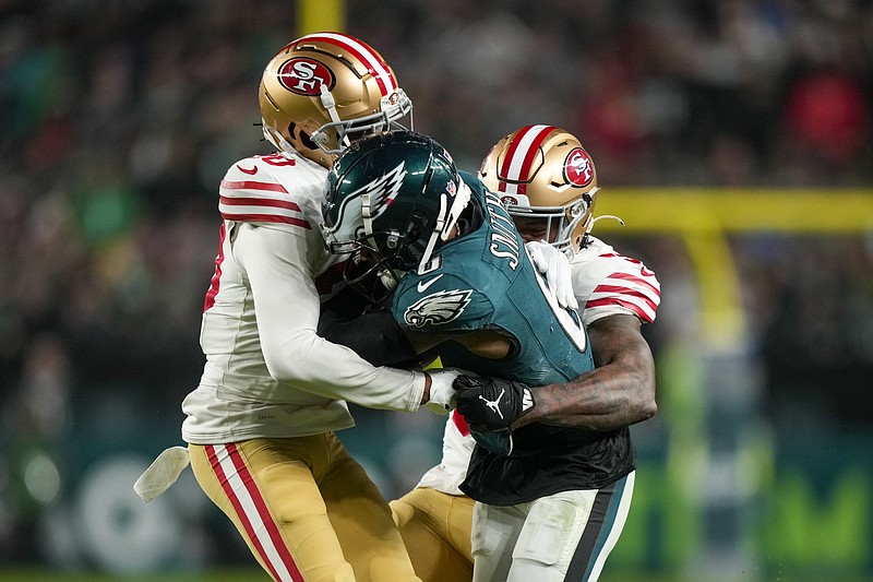Philadelphia Eagles wide receiver DeVonta Smith, center, is stopped by San Francisco 49ers cornerback Ambry Thomas, left, and linebacker Dre Greenlaw during the second half of an NFL football game, Sunday, Dec. 3, 2023, in Philadelphia. (AP Photo/Matt Slocum)