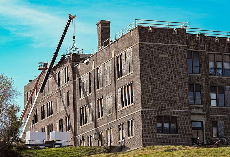 Julie Smith/News Tribune
ASR Roofing, Inc. continues to make progress on the old Simonsen Ninth Grade Center on East Miller Street. The building, once owned by the Jefferson City School District, sustained significant damage in the May 2019 tornado. Eventually the building was purchased by a developer who then sold it to the current owner, Stockman Stoneworks, which has been working on it since its acquisition earlier this year. While work is done to repair the roof, work is also being done inside to remove mold that thrived while the building was vacant.
