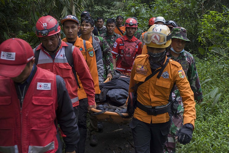 Rescuers carry a climber injured in the eruption of Mount Marapi in Agam, West Sumatra, Indonesia, Monday, Dec. 4, 2023. Indonesian authorities have halted Monday the search for 12 climbers after Mount Marapi volcano erupted again, unleashing a new burst of hot ash as high as 800 meters (2,620 feet) into the air, officials said. (AP Photo/Givo Alputra)