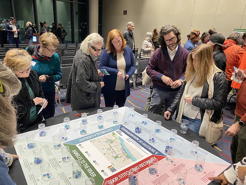 Attendees at a "community visioning workshop" held on Monday place tokens in jars to indicate support for certain ideas that might become part of a downtown Little Rock master plan. (Arkansas Democrat-Gazette/Joseph Flaherty)