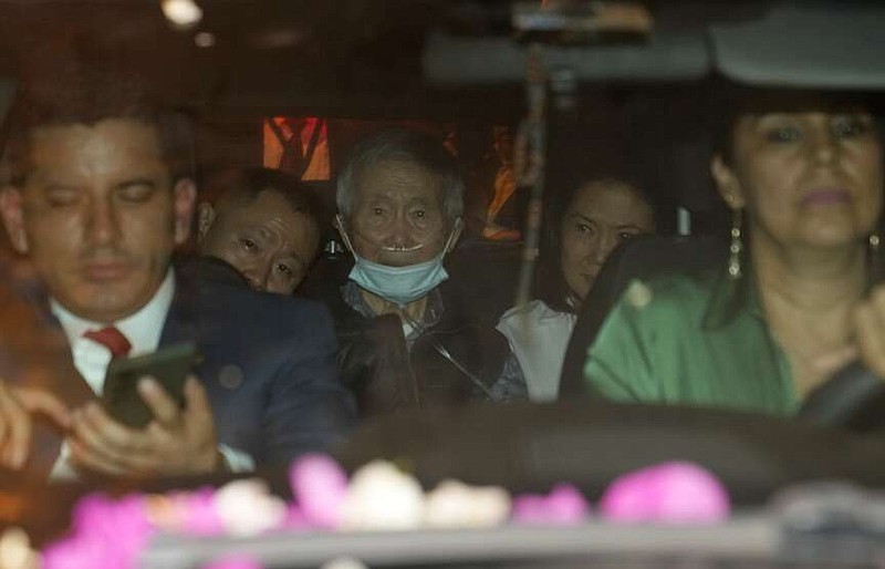 Peru's former President Alberto Fujimori, 85, center is driven out of prison by his children Keiko, center right, and Kenji, center left, after being released from prison in Callao, Peru, Wednesday, Dec. 6, 2023. The country's constitutional court ordered an immediate humanitarian release on Tuesday for the former leader who was serving a 25-year sentence for human rights abuses. (AP Photo/Martin Mejia)