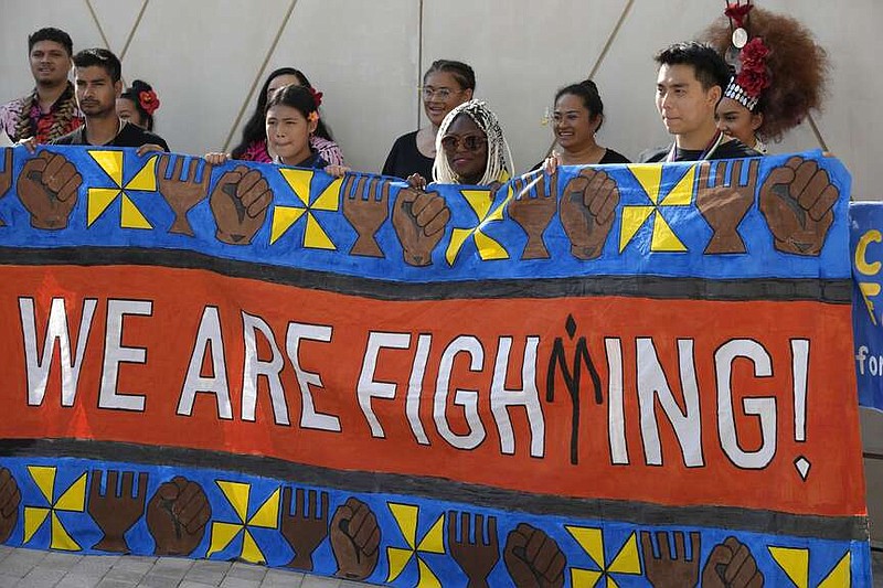 Activistas sostienen una pancarta con la frase "Estamos luchando" durante la cumbre climática de Naciones Unidas, COP28, el 8 de diciembre de 2023, en Dubái, Emiratos Árabes Unidos. (AP Foto/Peter Dejong)