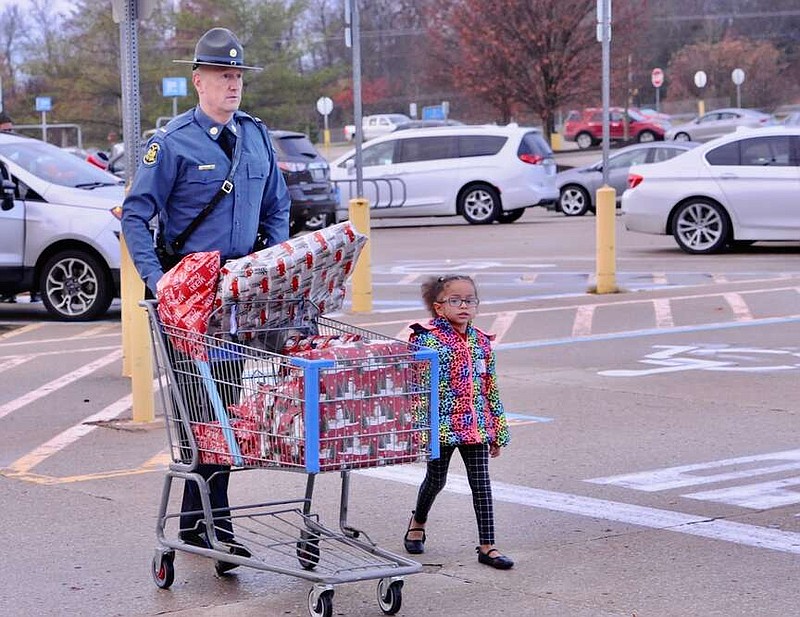 Joe Gamm/News Tribune
Missouri State Highway Patrol Lt. Thad Wilson takes the Christmas toys of Hazel Marie Lee, 4, to her mothers waiting car Saturday morning. The duo shopped at Walmart during the annual Operation Take Our Youth Shopping (TOYS) event.