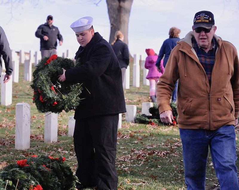 Joe Gamm/News Tribune photo: 
Sea Cadet apprentice Nick Jackson, 14, carries a handful of wreaths to a staging area before they are to be placed on gravestones Saturday morning, Dec. 9, 2023, at Jefferson City National Cemetery as part of Wreaths for Heroes.