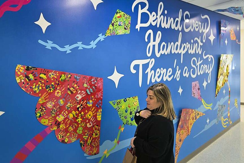 Elizabeth Shackelford, executive director of the Childrenâ€™s Safety Center, stands in front of a mural gifted to the center by the Saatchi and Saatchi X advertising firm, Thursday, December 7, 2023 at the new Child Safety Center in Springdale. The Child Safety Center in Springdale has opened their new location. They plan to hold a grand opening ceremony on Tuesday. Visit nwaonline.com/photos for today's photo gallery.

(NWA Democrat-Gazette/Charlie Kaijo)