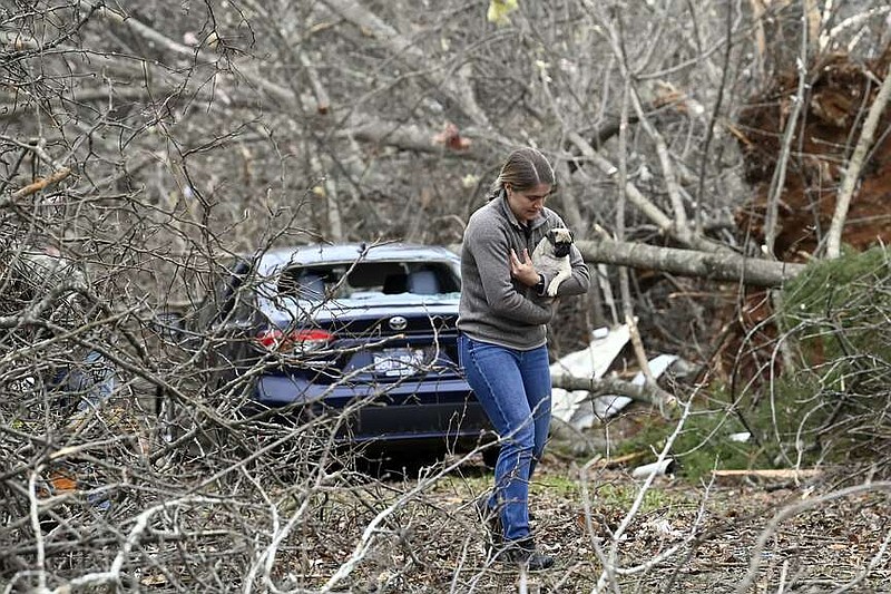 Andrea Remberger returns a lost dog to its owner, Sunday, Dec. 10, 2023, in Clarksville, Tenn. Tornados caused catastrophic damage in Middle Tennessee on Saturday afternoon and evening, Dec. 9. (AP Photo/Mark Zaleski)