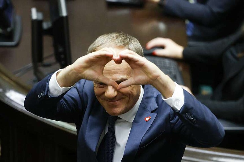 Donald Tusk shows a heart with his hands to lawmakers after he was elected as Poland's Prime Minister at the parliament in Warsaw, Poland, Monday Dec. 11, 2023. (AP Photo/Michal Dyjuk)