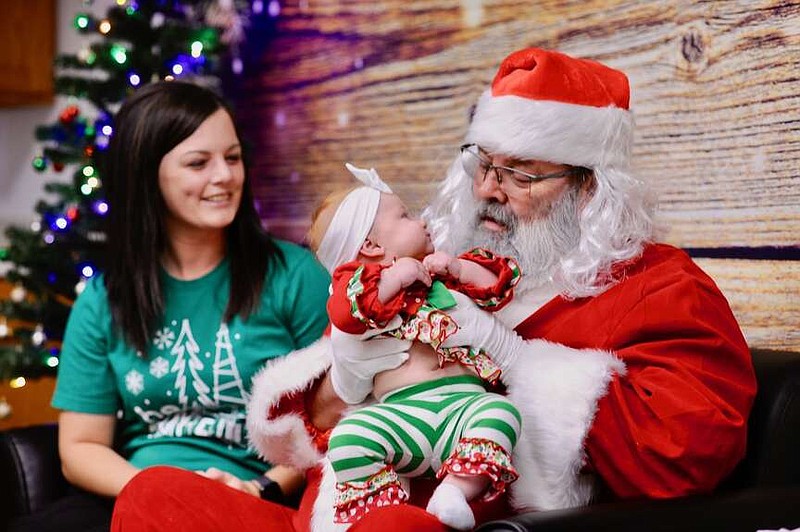 Joe Gamm/News Tribune photo: 
Ava Rustemeyer keeps a watchful eye on Santa as her mother, Rene Rustemeyer, looks on Wednesday morning, Dec. 13, 2023, at the Special Learning Center. The center serves more than 900 clients with programs for special needs.