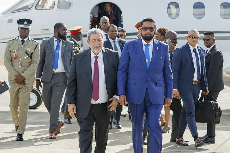 El presidente de Guyana Irfaan Ali (d) con el primer ministro de San Vicente y las Granadinas,  Ralph Gonsalves, cuando Ali llegaba a Argyle, San Vicente, el 14 de diciembre de 2023.  (Foto AP /Lucanus D. Ollivierre)