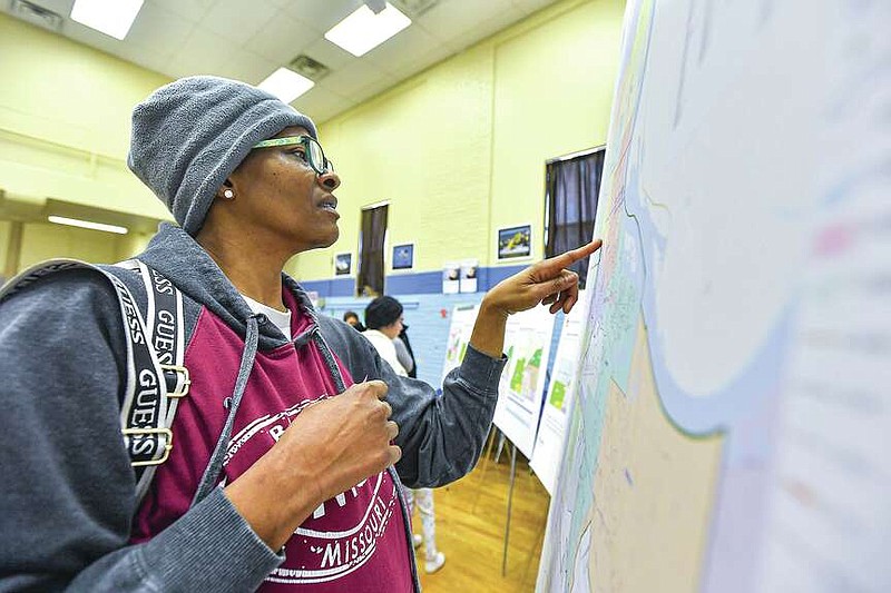 Lauretta Hill, the mother of a Trusty Elementary School student, looks for her address on a boundary map, Thursday, Dec. 14, at a public input meeting inside the auditorium at the elementary school in Fort Smith. The Fort Smith Public Schools district hosted several public input meetings this month to discuss the options for combining schools after closing Trusty Elementary at the end of the 2023-2024 school year. Visit rivervalleydemocratgazette.com/photo for today's photo gallery.
(River Valley Democrat-Gazette/Hank Layton)
