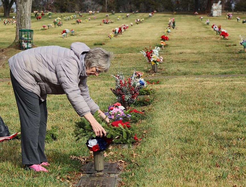 Alexa Pfeiffer/News Tribune photo: 
Barbara Heinrich lays a wreath on her father's grave marker Saturday, Dec. 16, 2023, at Hawthorn Memorial Gardens during the Wreaths Across America ceremony. The ceremony honors the sacrifices of veterans during the holiday season.