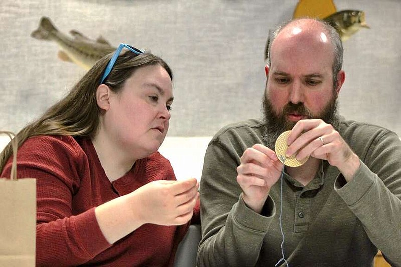 Alexa Pfeiffer/News Tribune photo:
Niki Feeler, left, and her husband, Preston, learn to cross stitch at a nature-themed event held Saturday, Dec. 16, 2023, at the Runge Nature Center in Jefferson City. The event provided all of the supplies needed and walked students through the pattern.