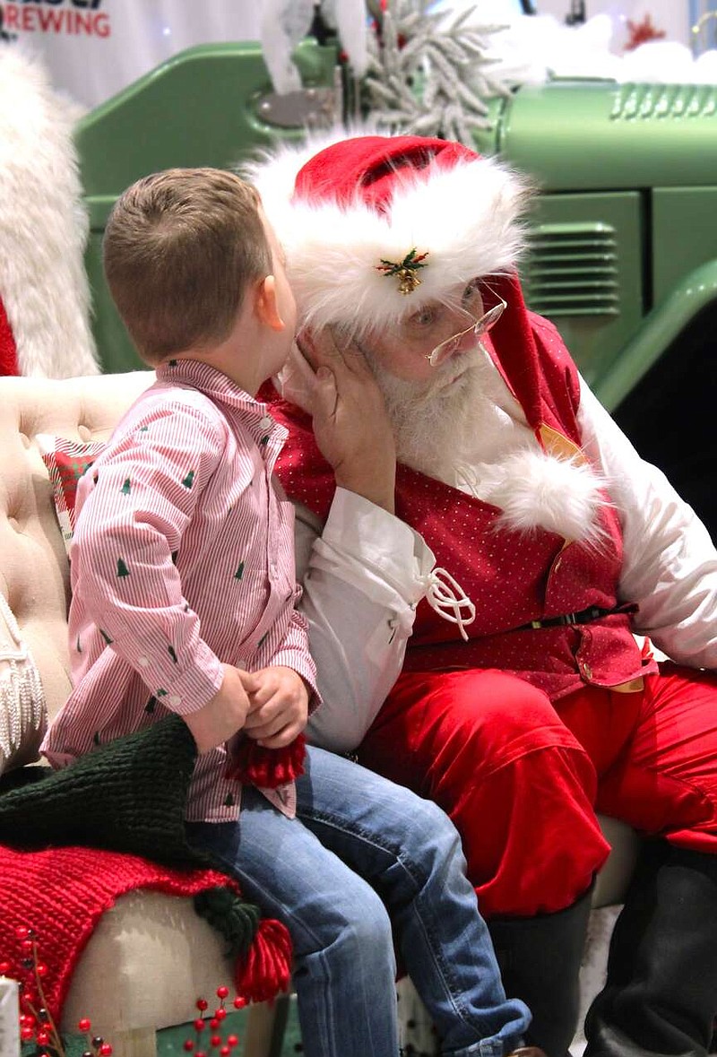 Alexa Pfeiffer/News Tribune photo: 
Jaxon Ehase, 4, whispers a secret to Santa about his Christmas wishes for 2023 at a meet and greet held Dec. 13 at Rusty Drewing Toyota in Jefferson City. The event featured visits with Santa, as well as snacks and activities for families to enjoy.