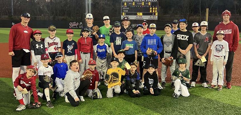 Arkansas Razorback pitcher Austin Ledbetter, left in red, stands with a group of kids at Majestic Park pitching camp. Razorback pitcher Will McEntire, far right, also put on the camp as part of a name, image and likeness deal. (Submitted photo)