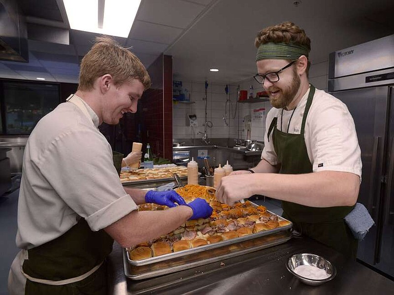 Chefs Trevor Meredith (left) and Micah Klasky from The Hive in Bentonville prepare pastrami sliders with kraut chi in this file photo. Chef Klasky and The Hive at 21c Museum Hotel in Bentonville will play host to the Guest Chef Dinner to benefit No Kid Hungry on Jan. 27.

(NWA Democrat-Gazette File Photo/Ben Goff)