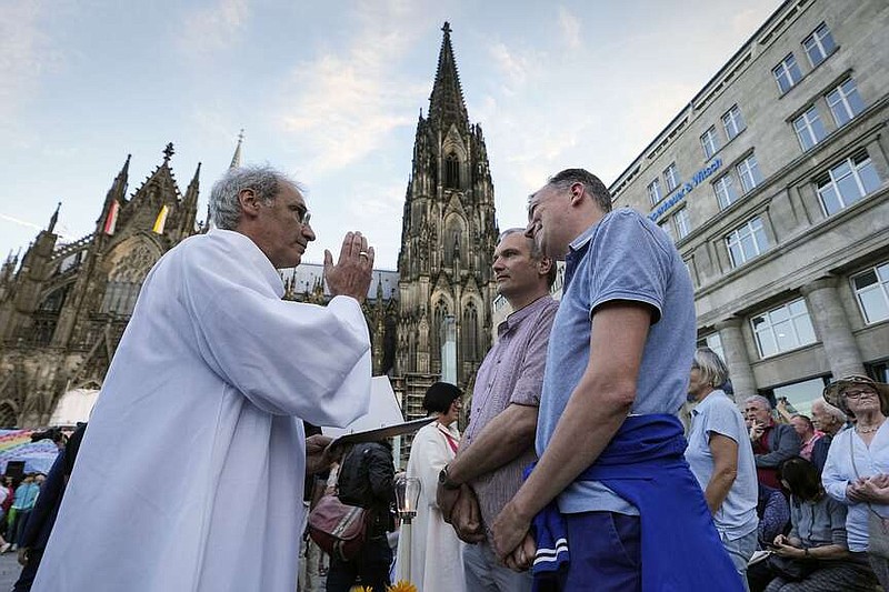 FILE - Same-sex couples take part in a public blessing ceremony in front of the Cologne Cathedral in Cologne, Germany, on Sept. 20, 2023. Pope Francis has formally approved allowing priests to bless same-sex couples, with a new document released Monday Dec. 18, 2023 explaining a radical change in Vatican policy by insisting that people seeking God's love and mercy shouldn't be subject to “an exhaustive moral analysis” to receive it. (AP Photo/Martin Meissner, File)