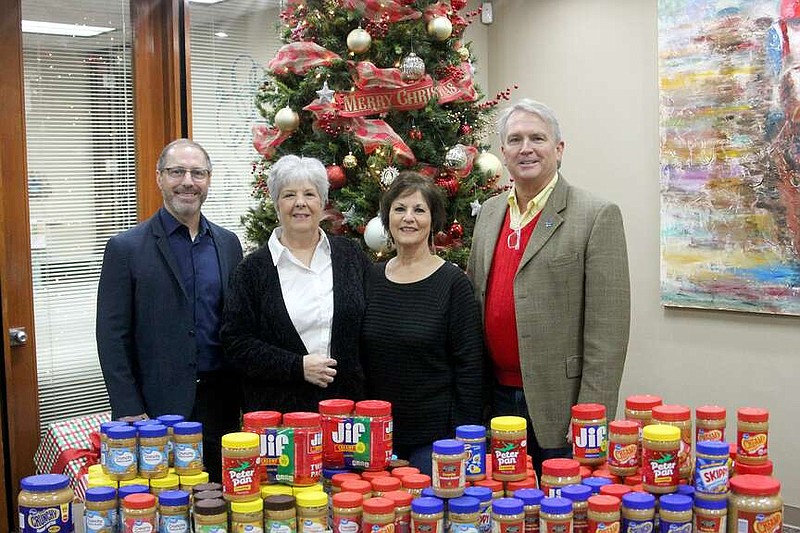 Project HOPE Assistant Director Becky Choate, second from left, accepted dozens of jars of peanut butter collected at the 18th annual Ice on Ice fundraiser. Lauray's The Diamond Center owner Toddy Pitard, left, Greater Hot Springs Chamber of Commerce Vice President Vickie Gilliam and Greater Hot Springs Chamber of Commerce President and CEO Gary Troutman also presented a check for $5,500 to the food bank. (The Sentinel-Record/James Leigh)