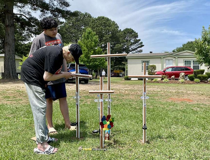Charity Lopez and her son, Adrian Vargas, install crosses in the front yard of the house where the bodies of four members of the Olalde family were discovered Tuesday, May 23, 2023, on Lemon Acres in Nash, Texas. Cesar Olalde, 18, who reportedly had barricaded himself in the house, surrendered to police and was arrested at the scene. The teenager is charged with capital murder in the deaths of his parents, brother and sister. (File photo by Stevon Gamble)