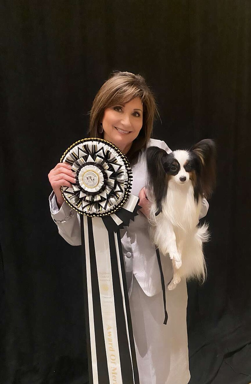 Paula Cox poses for a photo with one of her papillons after winning an award during a competition in Virginia Beach. (Contributed photo)