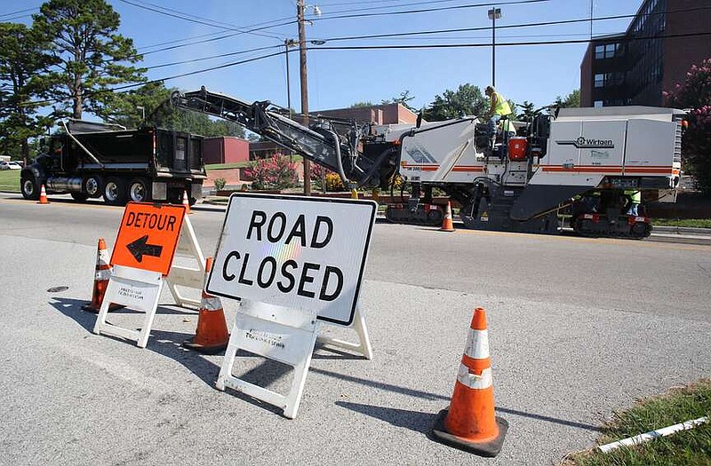 City crews work in 2017 on milling and placing an asphalt overlay on North Street between College and Gregg avenues. The City Council recently approved a new agreement with the same company that used a trailer to analyze the condition of streets in the city five years ago. (File photo/NWA Democrat-Gazette/David Gottschalk)