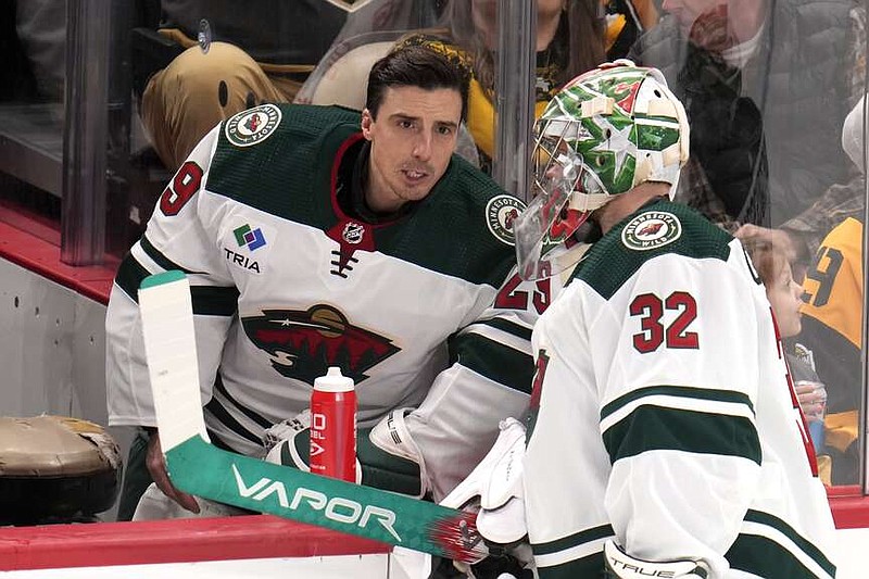 Minnesota Wild goaltender Filip Gustavsson (32) talks with Marc-Andre Fleury during a timeout in the first period of an NHL hockey game against the Pittsburgh Penguins in Pittsburgh, Monday, Dec. 18, 2023. (AP Photo/Gene J. Puskar)
