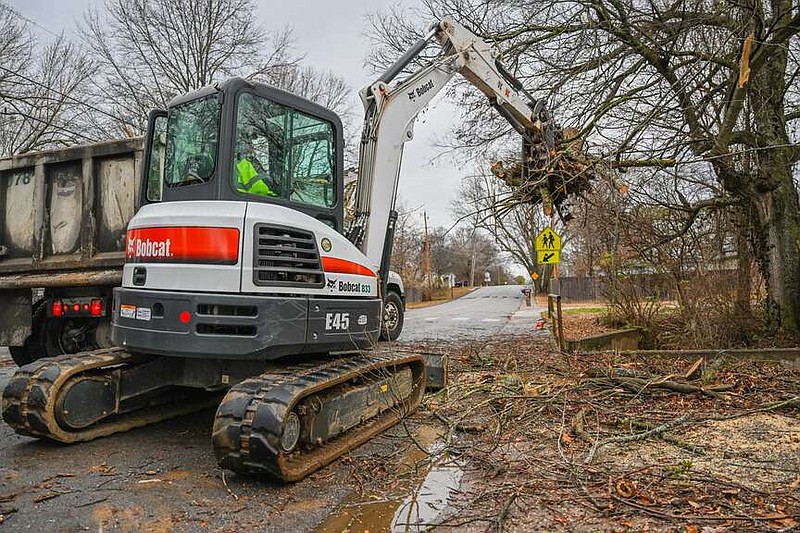 City of Fayetteville worker Tim Fletcher clears fallen branches from a tree with a backhoe on Monday, Jan. 8, 2024, in Fayetteville. The high winds earlier in the day knocked down large branches along Sang Avenue that landed in a yard and across the sidewalk. Visit nwaonline.com/photo for today's photo gallery. (NWA Democrat-Gazette/Caleb Grieger)