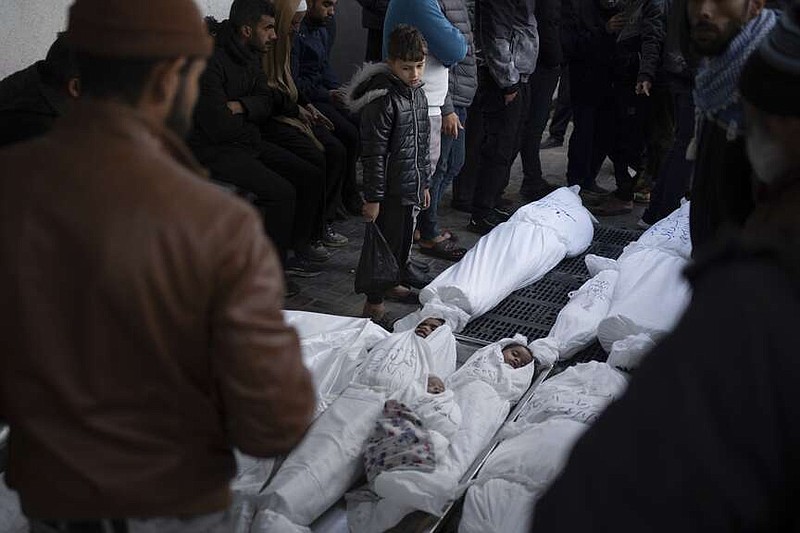 Palestinos lamentan la muerte de familiares, incluidos niños que perdieron la vida en un bombardeo israelí sobre la Franja de Gaza, el jueves 11 de enero de 2024, fuera de una morgue en Rafah, en el sur de Gaza. (AP Foto/Fatima Shbair)
