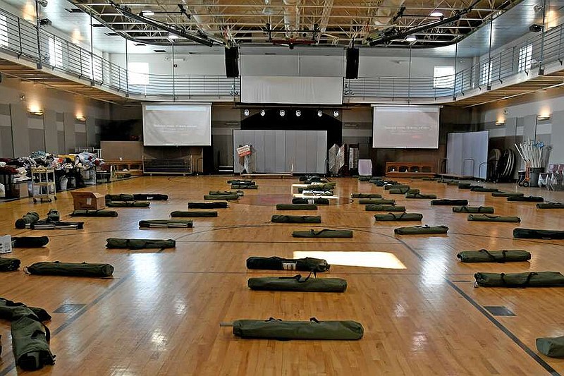 Rows of unassembled cots lie on the floor of the gym in the Cupp Family Life Center at First United Methodist Church. The building is host to the emergency warming shelter, and it is expected to remain open through Wednesday morning. (The Sentinel-Record/Lance Brownfield)