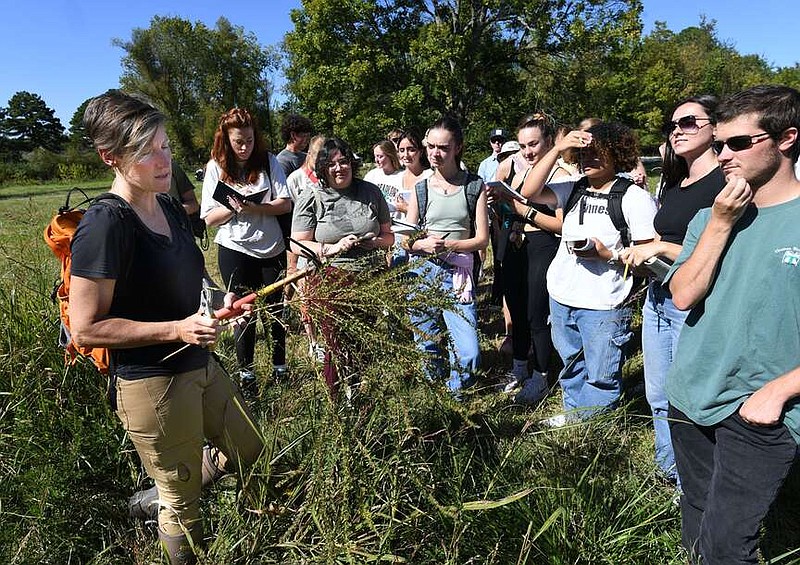 Jennifer Ogle (left), herbarium collections manager at the University of Arkansas, speaks Monday, Oct. 9, 2023, to a group of students from the Department of Landscape Architecture about plants found in Underwood Park during a tour of the park in Fayetteville. The students are learning about the new 58-acre park from scholars of several disciplines while creating a master plan for the park for academic purposes. Visit nwaonline.com/photo for today's photo gallery.
(NWA Democrat-Gazette/Andy Shupe)