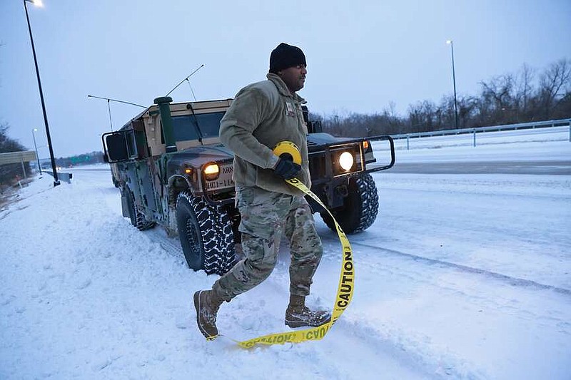 Arkansas Air National Guard Technical Sgt. Latham Lewis prepares to check on an unattended vehicle on the side of I-40 on Monday, Jan. 15, 2024. The vehicle was spotted on the side of the highway by the national guard members as they patrolled the area looking for stranded motorists. An earlier version of this caption misidentified the branch of the National Guard. See more photos at arkansasonline.com/116snow/ (Arkansas Democrat-Gazette/Colin Murphey)