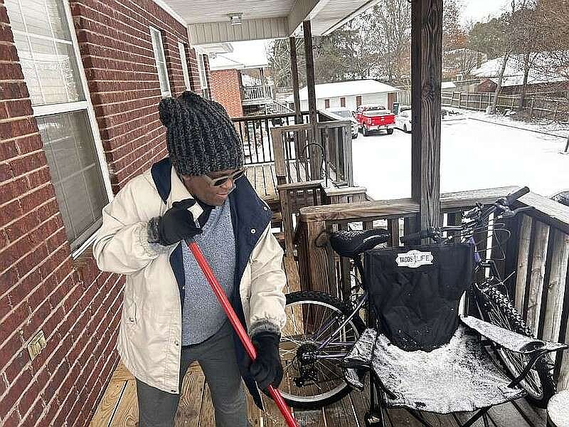 Jeanette Sams, of Texarkana, Texas, bundles up to sweep snow off her front porch while taking in some fresh air on Monday, Jan. 15, 2024. (Staff photo by Sharda James)