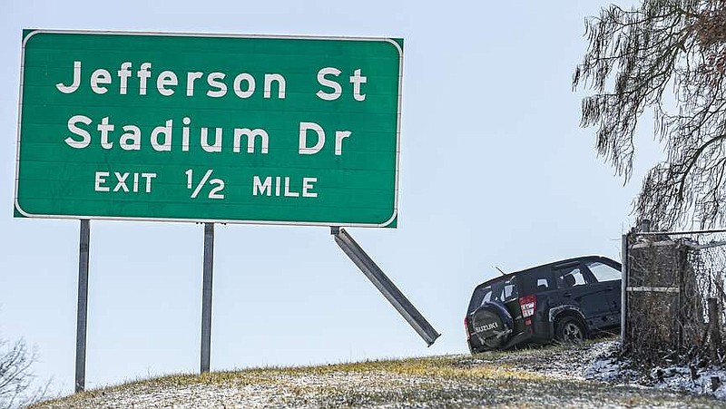 Julie Smith/News Tribune
A vehicle remains Tuesday afternoon where it stopped after running off the roadway of westbound U.S. 54 near South School and hitting a sign post before coming to a stop.