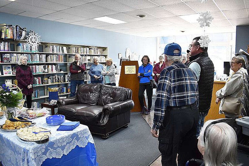 Democrat photo/Garrett Fuller — Moniteau County Library patrons gather Jan. 17 as Mike Staton, third from right in black vest, speaks about how the library's former director, Connie Beauchamp, right, impacted the community. Beauchamp retired Dec. 31 after spending nearly 14 years transforming the Wood Place Library — as it was originally called when she started in 2010 — to its current form, a publicly-funded library that serves Moniteau County except the City of Tipton. Staton is a member of the library's Board of Trustees, which he previously headed.